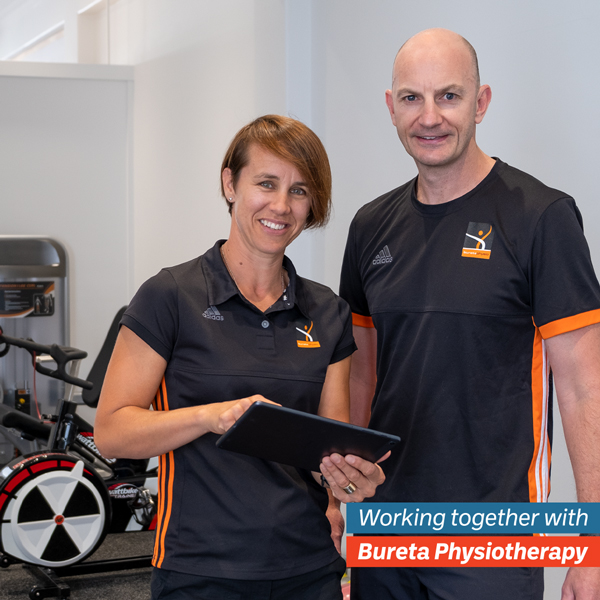 Jacs and Blair from Bureta Physio standing in a gym.